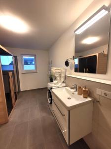 ein Bad mit einem Waschbecken und einem Spiegel in der Unterkunft Winterberg Appartement 21126 in Winterberg