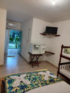 a room with two beds and a television in it at Pousada Rancho Texas Ubatuba in Ubatuba
