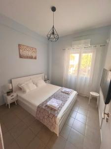 a bedroom with a large bed and a television at AKTIS apartment 3 near airport in Artemida