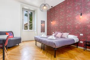 een slaapkamer met een bed en een rode muur bij FEEL - Palazzo Centrale in Bergamo