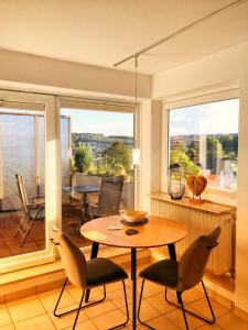 cocina y comedor con mesa y sillas en Sonnenplätzchen mit Dachterasse mitten in Wiehl, en Wiehl