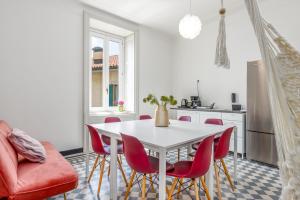 cocina con mesa blanca y sillas rojas en FEEL - Palazzo Centrale en Bérgamo