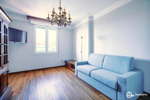 sala de estar con sofá azul y ventana en [Elegant Apartment]-con Free Wi-Fi & A/C, en San Remo