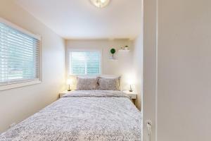 - une chambre blanche avec un lit et deux lampes dans l'établissement Coastal Happiness, à Waldport