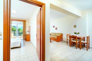 a living room with a table and a dining room at Ladikas apartments in Chrysi Ammoudia