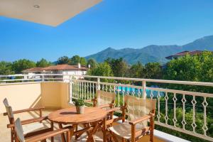 a balcony with a table and chairs and mountains at Ladikas apartments in Chrysi Ammoudia
