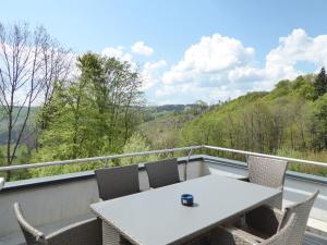 een tafel en stoelen op een balkon met uitzicht bij Winterberg Cityflair Wifi Pool Sauna 6 Pers PS4 Netflix near Bikepark in Winterberg