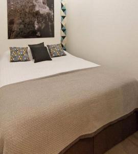 uma cama com três almofadas num quarto em Jeux Olympiques 2024, Stade de France em Saint-Denis