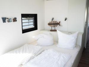 2 bedden in een kamer met witte kussens bij WELL Hausboote in Boltenhagen