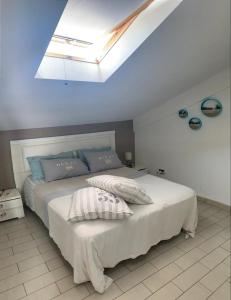 サンタ・マリア・デル・フォカッロにあるEsperienza Luxury fronte mare con piscinaのベッドルーム(天窓付きの大きな白いベッド1台付) +23枚の写真