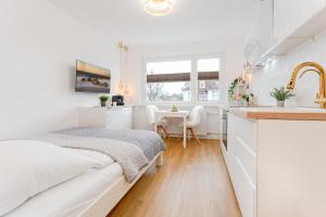 um quarto branco com uma cama e uma cozinha em Beach Vibes em Timmendorfer Strand