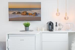 uma cozinha com armários brancos e uma imagem na parede em Beach Vibes em Timmendorfer Strand