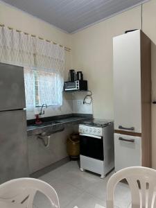 uma cozinha com um fogão e um frigorífico branco em Flat próx. Rodov. e Aeroporto em Palmas