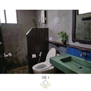 a bathroom with a toilet and a green sink at บ้านณัฐวรรณ หัวหิน - Baan Nattawan Huahin in Hua Hin