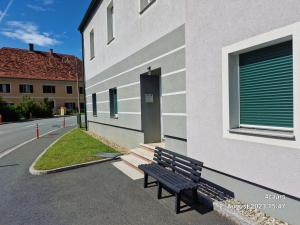 a black bench sitting outside of a building at Voll ausgestattet, Nähe Heiltherme Bad Waltersdorf 