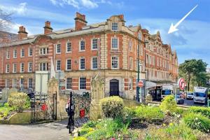 a large brick building with a white arrow on it at The Gallery - Bournemouth Town Centre - Beach 5 Minute Walk - Superfast WiFi - Outdoor Terrace - Sleeps 6 - Netflix - Contractor Friendly - Long Stay Rates - Coffee Machine in Bournemouth
