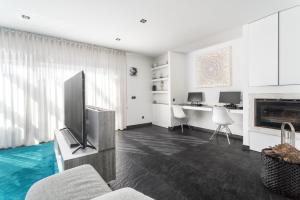uma sala de estar com uma televisão e um sofá em Host Wise - Luxurious House with Private Salt Pool em Ferragudo