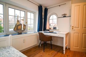 una camera da letto con scrivania e una barca alla finestra di Ferienwohnung Veras Kate a Greetsiel Altre 15 foto