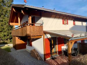 une petite maison avec une terrasse couverte et une terrasse dans l'établissement Feriendorf Via Claudia Ferienhaus Martin, à Lechbruck am See