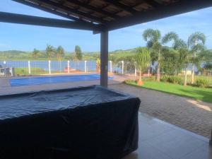 ein Schlafzimmer mit einem Bett mit Blick auf einen Pool in der Unterkunft Rancho em Capitólio-MG in Capitólio
