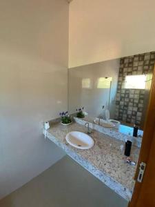 La salle de bains est pourvue d'un lavabo et d'un miroir. dans l'établissement Rancho em Capitólio-MG, à Capitólio