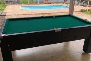 einen Billardtisch vor einem Pool in der Unterkunft Rancho em Capitólio-MG in Capitólio