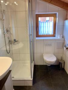 a bathroom with a shower and a toilet and a sink at Feriendorf Via Claudia Ferienhaus Lechsee in Lechbruck