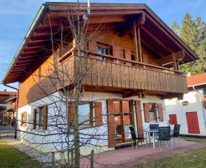 a house with a deck on the side of it at Feriendorf Via Claudia Ferienhaus Lechsee in Lechbruck
