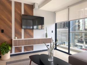 a living room with a tv on a wall at Navarrete Residence in Premium San Isidro by Wynwood House in Lima
