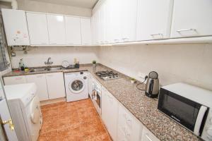 バルセロナにあるBlaiのキッチン(白いキャビネット、洗濯機、乾燥機付)