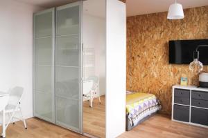 モントルイユにあるBeautiful renovated studio in dynamic neighborhoodのベッドルーム(ガラス張りのクローゼット、ベッド1台、テレビ付)
