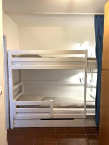 Ce lit superposé blanc se trouve dans un dortoir. dans l'établissement Haus Nordseeblick Wohnung 113, à Norderney