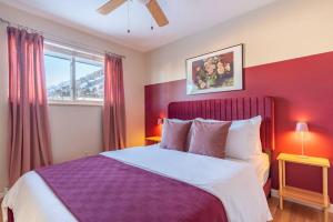 a bedroom with a purple bed and a window at Downtown Denver: 4bd - Game/Movie Room - Backyard in Arvada