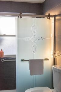 a bathroom with a toilet and a glass shower door at Downtown Denver: 4bd - Game/Movie Room - Backyard in Arvada +54 photos
