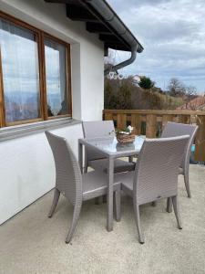 einen Tisch und Stühle auf einer Terrasse in der Unterkunft Tévenon Vue Panoramique Alpes-Lac in Grandevent