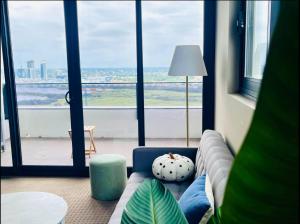 a living room with a couch and a large window at Panoramic City View 3bedroom condo Wi-Fi Parking in Sydney