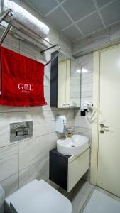 baño con lavabo blanco y toalla roja en GÜL RESİDENCE, en Pamukkale