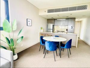 a dining room with a table and blue chairs at Panoramic City View 3bedroom condo Wi-Fi Parking in Sydney