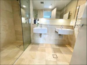 a bathroom with two sinks and a shower at Panoramic City View 3bedroom condo Wi-Fi Parking in Sydney +19 photos