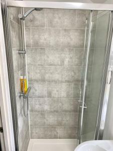 a bathroom with a shower with a glass door at In Royal Leamington Spa 4 bed with free parking in Leamington Spa