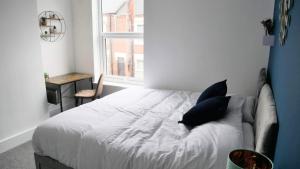 a white bed in a room with a window at Stoke - 3 Bedroom House - Winifred St. in Stoke on Trent