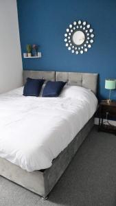 een slaapkamer met een groot bed met een spiegel aan de muur bij Stoke - 3 Bedroom House - Winifred St. in Stoke on Trent