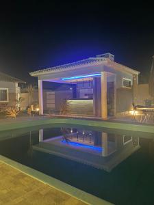 a house with a swimming pool at night at A Casa in Maricá