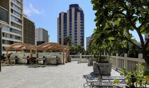 a patio in the middle of a city with tall buildings at Stylish Studio with Great Ocean Views & Near Beach! in Honolulu