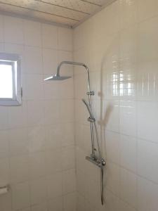 a shower with a shower head in a bathroom at Theresa Lodge. in Port Loko