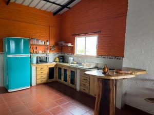 a kitchen with a refrigerator and a table in it at Finca Aguadalupe, Lago Calima in Calima