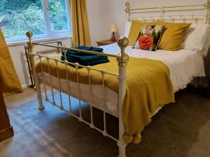 a bedroom with a bed with a yellow blanket at Beach Front Coastal Retreat with Sea Views in Kingsbridge