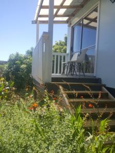 a chair sitting on the porch of a house at Mountain View Studio in Raglan