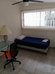 a bedroom with a bed and a desk and a desk at Preciosa casa totalmente amueblada y equipada. in Veracruz