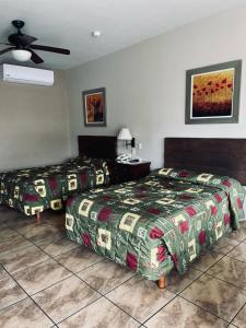 a bedroom with two beds and a ceiling fan at Hotel las Palmas in Hermosillo